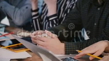 特写镜头，专业商务人士的双手在大型办公桌上与咖啡和设备合作开会。